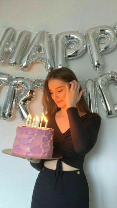 a woman holding a cake with lit candles in front of her face and the words happy birthday on it