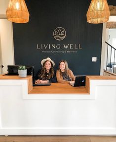 two women sitting at the front desk of living well