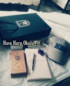 a hat, notebook and other items are on a bed with the words hava harp oku next to it