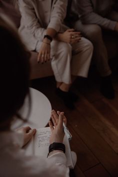 two people are sitting on a couch and one person is writing