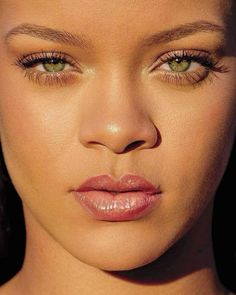 a close up of a woman's face with green eyes