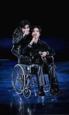 two people sitting in a wheelchair on stage