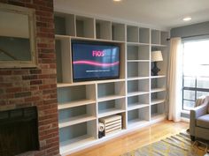 a living room filled with furniture and a flat screen tv on top of a book shelf