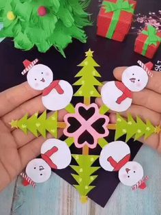 someone is holding up some christmas decorations on their fingers and making a snowman ornament