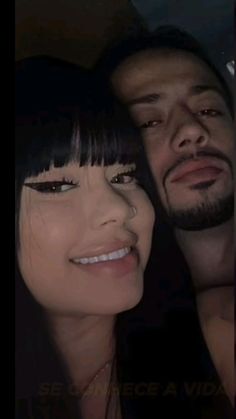 a man and woman are posing for a photo in the back seat of a car