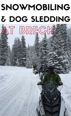 a man riding on the back of a snowmobile down a snow covered ski slope