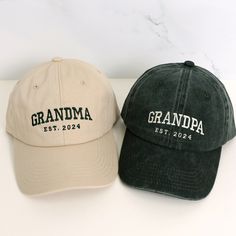 two hats that say grandma and grandpa est 2012 on the front one is black and tan