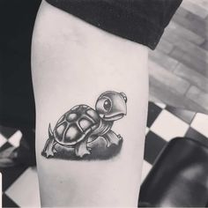 a black and white photo of a small turtle tattoo