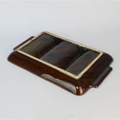 a brown and white tray with three chocolate bars on it's sides, sitting on top of a table