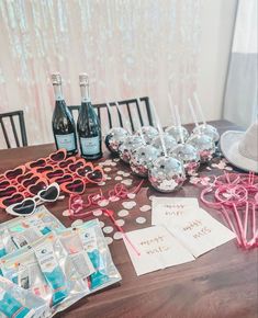 a table topped with lots of bottles of wine next to glasses and confetti