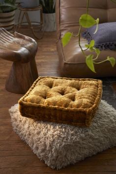 a brown square cushion sitting on top of a wooden floor