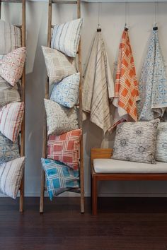 several different colored pillows hanging on a wall