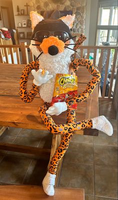 a stuffed animal sitting on top of a wooden table next to a bag of candy