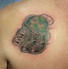 a man with a tattoo on his chest has an army helmet and boots in it