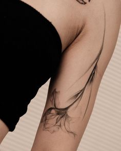 a woman's arm with a flower tattoo on the left side of her body