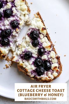 two pieces of bread with blueberries and cream on them are sitting on a white plate