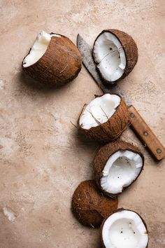 coconuts cut in half with a knife on the side