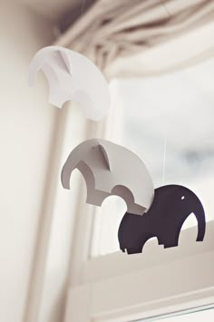 an elephant mobile hanging from a window sill