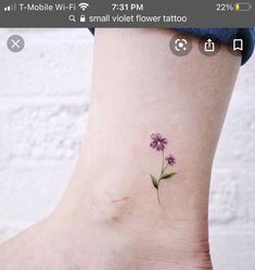 a small flower tattoo on the ankle that looks like it's growing out of the ground