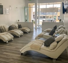 a living room filled with lots of couches on top of hard wood flooring