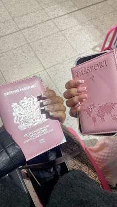 a person holding two pink passports in their hands