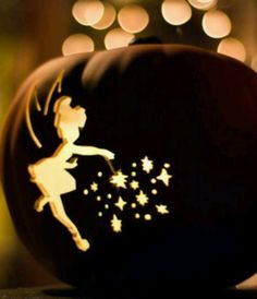 a pumpkin decorated with a silhouette of a girl and stars in the night sky, on top of a table