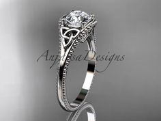 a white gold engagement ring with an intricate design on the band and center stone setting