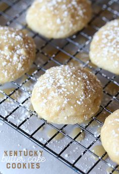 several sugar cookies cooling on a wire rack with powdered sugar sprinkles