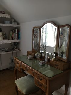 a desk with a mirror and stool in a room