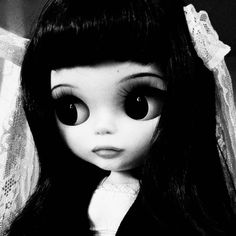 a black and white photo of a doll with big eyes