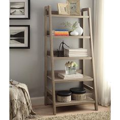 a bookshelf in a living room with pictures on the wall and a rug