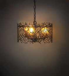 a chandelier with three lit candles in it hanging from a chain on the wall