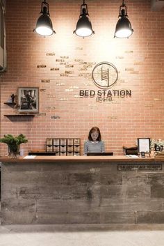 a woman sitting at the front desk of a bed station