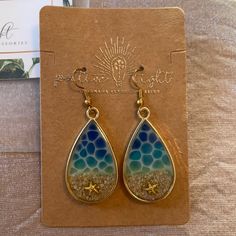 a pair of earrings sitting on top of a card