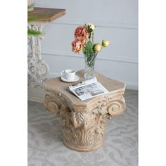 a vase with flowers sitting on top of a table next to a cup and saucer