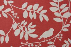 a red background with white leaves and birds on it