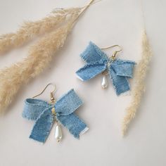 two pairs of earrings with bows and pearls hanging from the ends of each earring