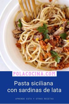 a white plate topped with pasta and meat next to a fork on top of a table