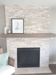 a living room with a white brick fireplace and a framed picture on the mantel