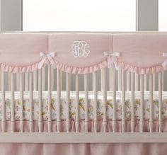 a baby crib with pink and white bedding