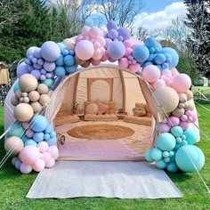 an arch made out of balloons in the shape of a tent with a couch inside