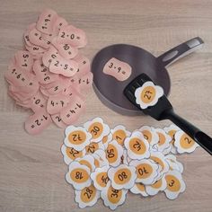 a table topped with lots of cut outs next to a frying pan filled with eggs