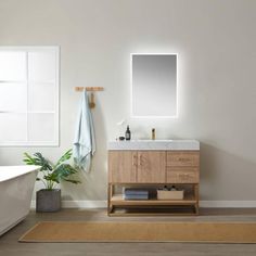 a bathroom with a sink, mirror and bathtub in the middle of the room