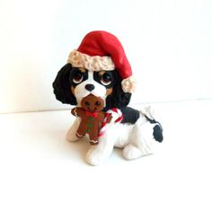 a dog figurine wearing a santa hat and holding a christmas ornament