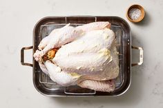 a raw chicken sitting on top of a metal pan