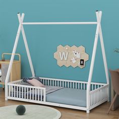 a white bed frame with the letter w on it in a child's room