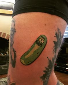 a person with a green sticker on their leg that has a pickle in it