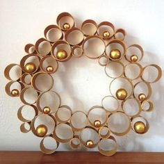 a gold circle sculpture sitting on top of a wooden table next to a white wall