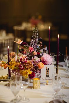 the table is set with flowers and candles