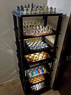 a shelf filled with lots of chess pieces on top of a wooden floor next to a door